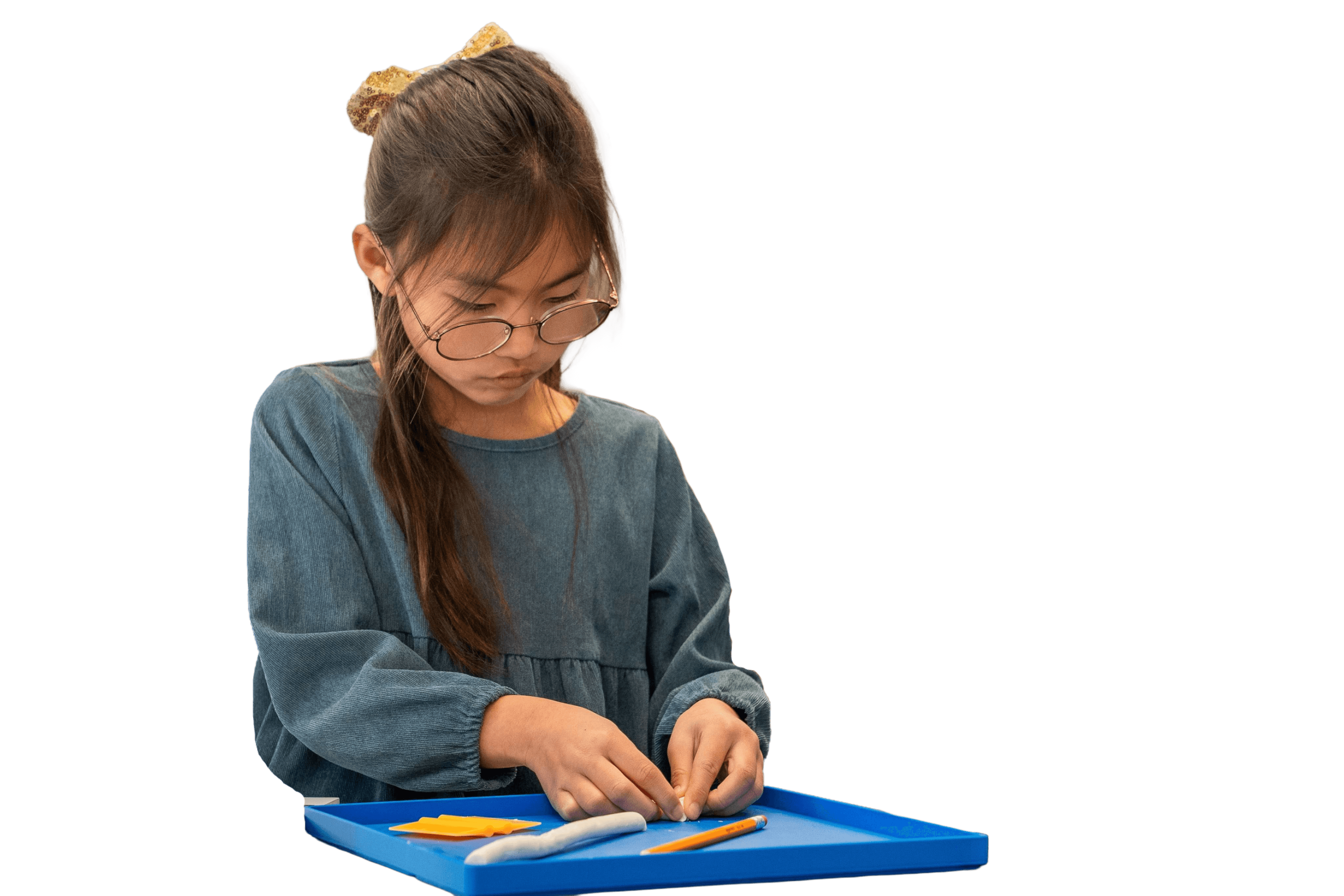 A child shaping clay letters on a tray